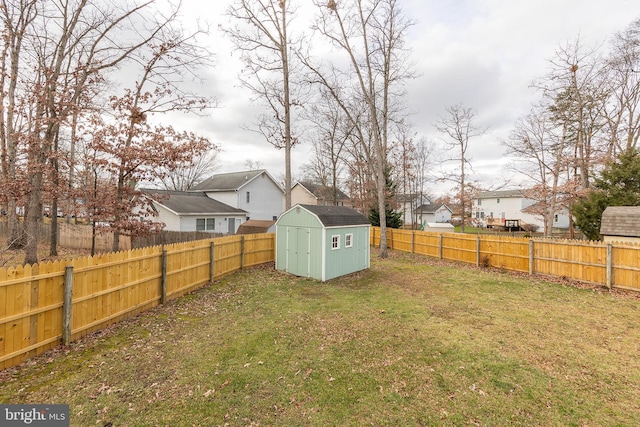 view of yard with a fenced backyard, a residential view, a storage shed, and an outdoor structure