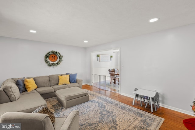 living area with recessed lighting, wood finished floors, and baseboards