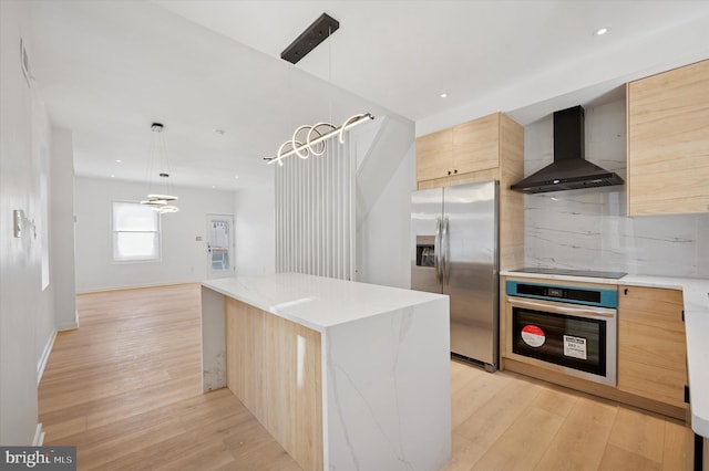 kitchen with backsplash, modern cabinets, light brown cabinets, wall chimney range hood, and stainless steel appliances