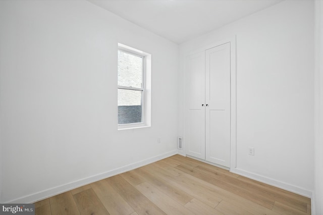 unfurnished room with baseboards, visible vents, and light wood-style floors