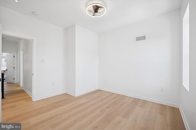 spare room featuring light wood-style flooring, baseboards, and visible vents