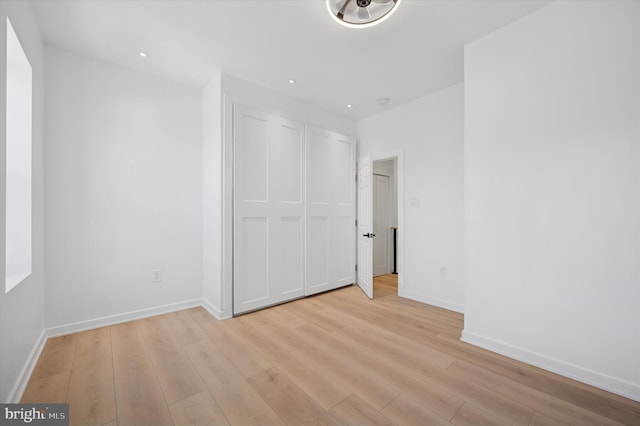 unfurnished bedroom featuring light wood finished floors, baseboards, and recessed lighting