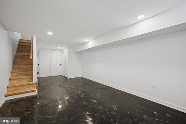 finished basement with stairs, recessed lighting, and baseboards