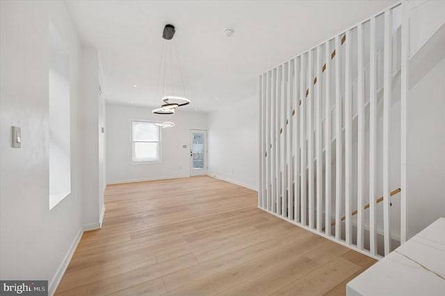 interior space with baseboards, light wood finished floors, and recessed lighting