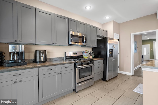 kitchen featuring recessed lighting, gray cabinets, appliances with stainless steel finishes, and baseboards