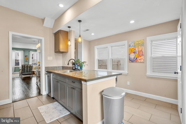 kitchen featuring a sink, visible vents, gray cabinetry, and a wealth of natural light