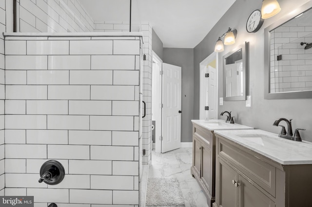 bathroom featuring a stall shower, two vanities, marble finish floor, and a sink