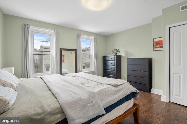 bedroom featuring visible vents, baseboards, and dark wood-style flooring