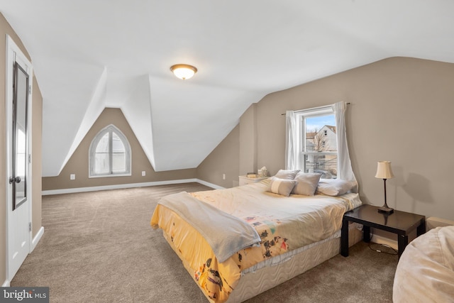 carpeted bedroom with baseboards and vaulted ceiling