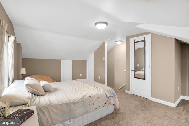 bedroom with carpet flooring, lofted ceiling, and baseboards