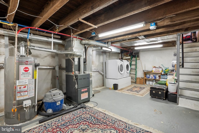 unfinished below grade area with stairs, heating unit, washing machine and dryer, and water heater