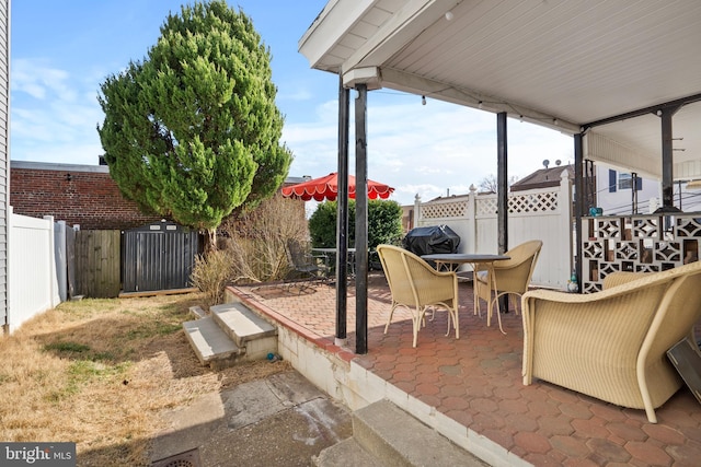 view of patio / terrace with a fenced backyard and a grill