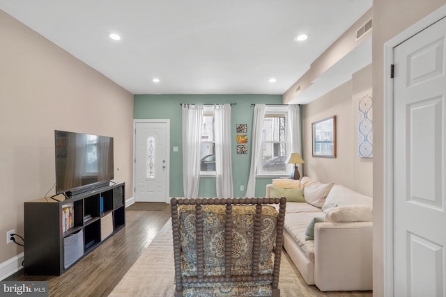 living area with recessed lighting, wood finished floors, visible vents, and baseboards