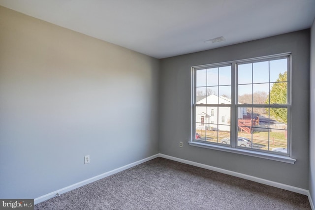 carpeted spare room featuring baseboards