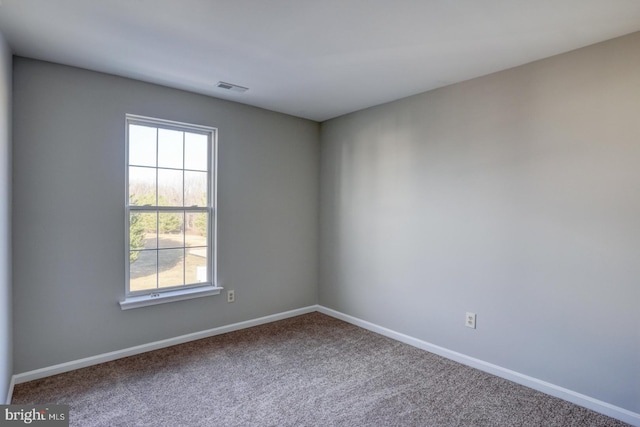 unfurnished room with visible vents, baseboards, and carpet floors