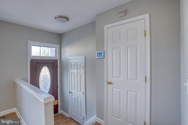 foyer entrance with baseboards and wood finished floors