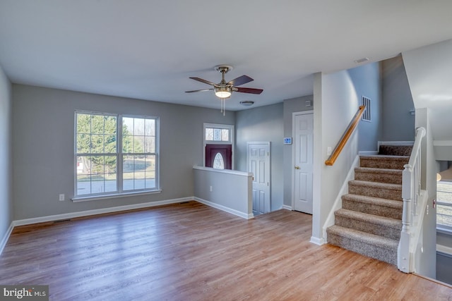 foyer featuring visible vents, a ceiling fan, stairway, light wood finished floors, and baseboards