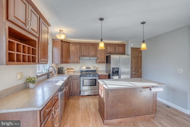 kitchen with visible vents, light wood-style flooring, under cabinet range hood, a sink, and stainless steel appliances