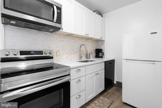 kitchen featuring a sink, dark wood finished floors, white cabinetry, appliances with stainless steel finishes, and light countertops