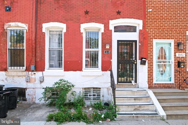 doorway to property featuring brick siding