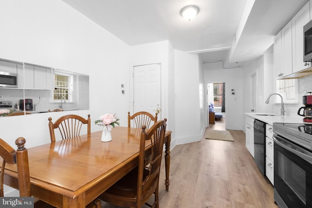 dining space with light wood-type flooring and baseboards