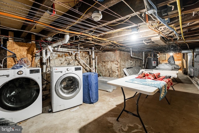 unfinished below grade area featuring washing machine and clothes dryer and water heater