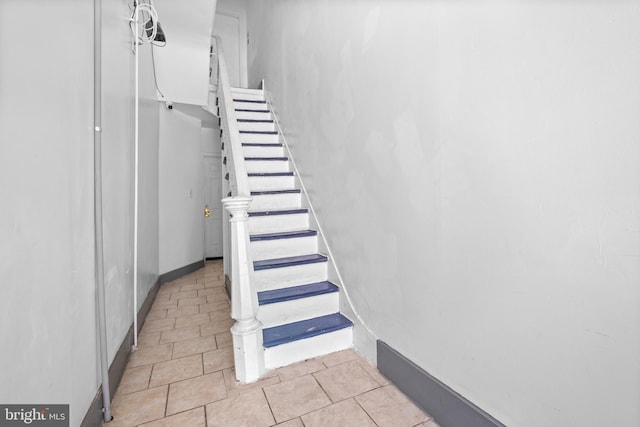 staircase with tile patterned floors and baseboards