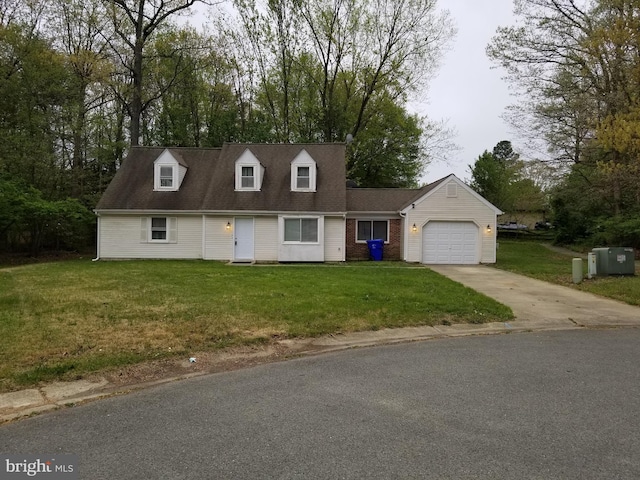 new england style home featuring brick siding, a garage, a front yard, and driveway