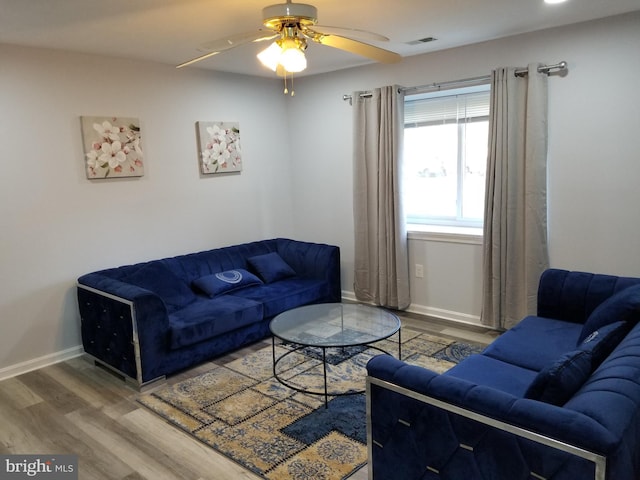 living area with visible vents, wood finished floors, baseboards, and ceiling fan