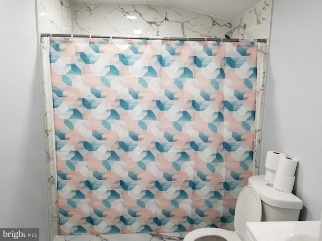 bathroom featuring a shower with shower curtain and toilet