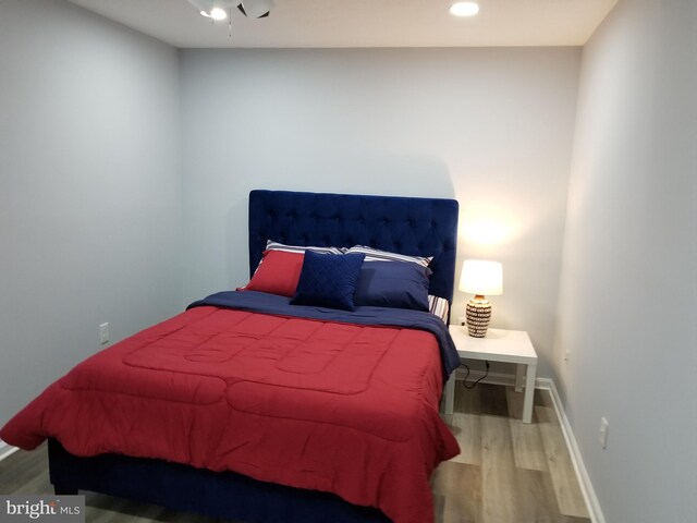 bedroom with recessed lighting, wood finished floors, and baseboards