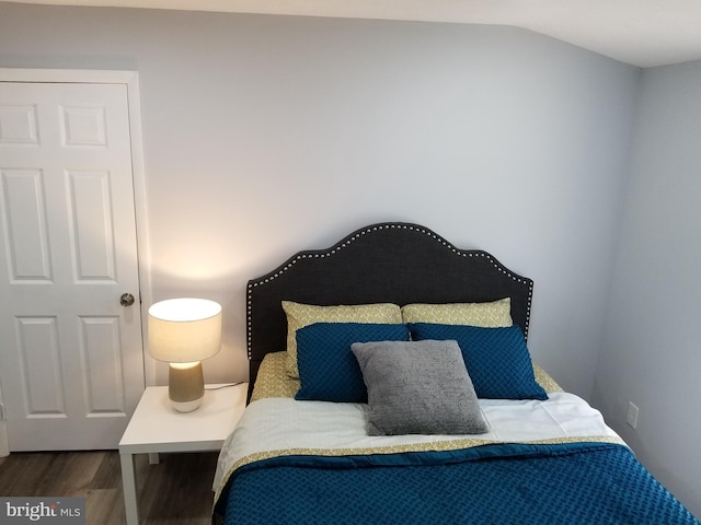 bedroom featuring wood finished floors and vaulted ceiling