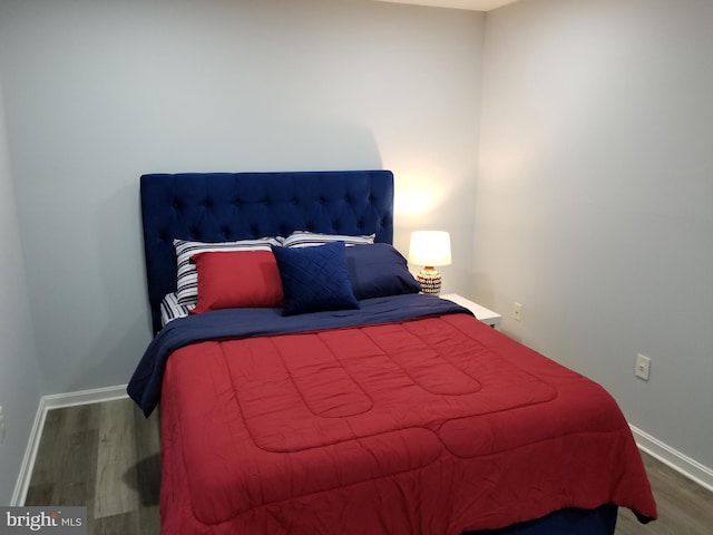 bedroom with baseboards and wood finished floors