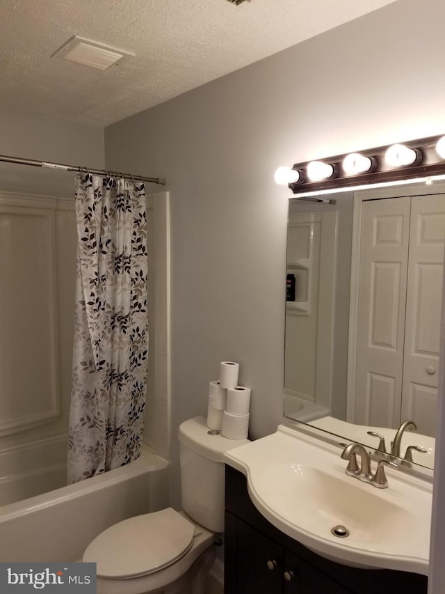 full bathroom featuring vanity, toilet, shower / tub combo with curtain, and a textured ceiling