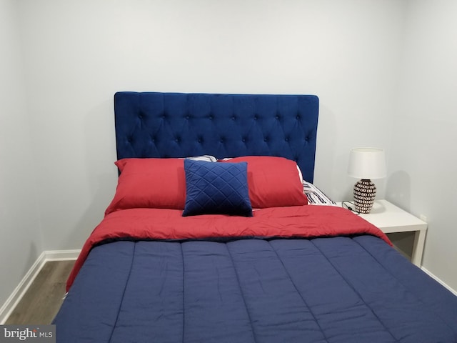 bedroom featuring wood finished floors and baseboards