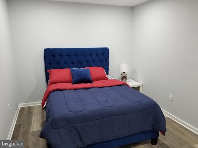 bedroom featuring baseboards and wood finished floors