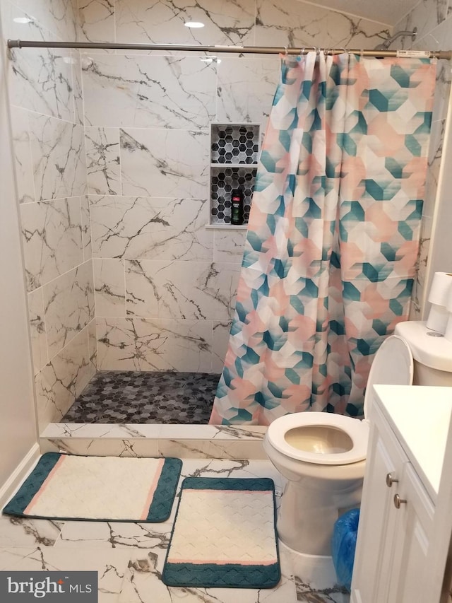 bathroom with vanity, toilet, a stall shower, and marble finish floor