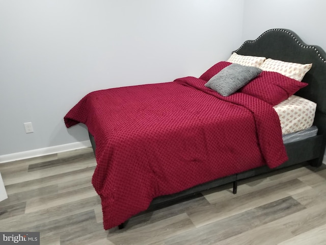 bedroom featuring baseboards and wood finished floors