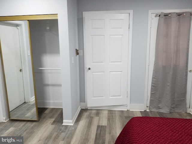 bedroom featuring a closet, baseboards, and wood finished floors