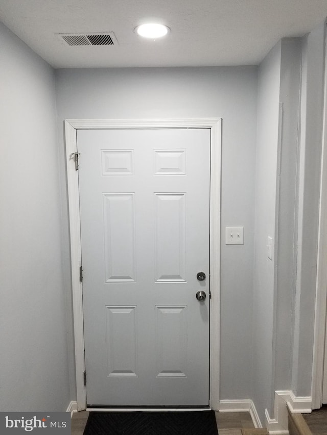 doorway with recessed lighting, visible vents, baseboards, and dark wood-type flooring