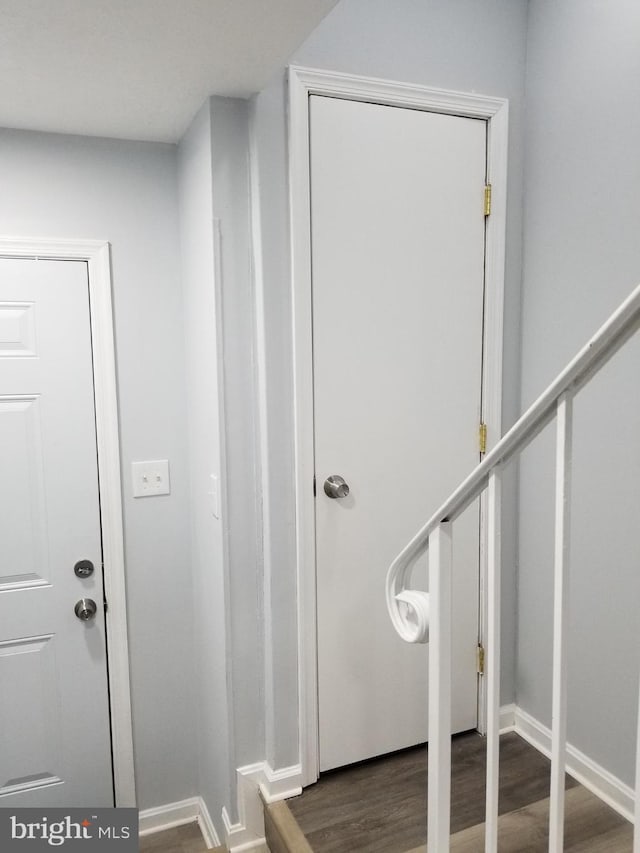 entrance foyer featuring stairway, baseboards, and wood finished floors