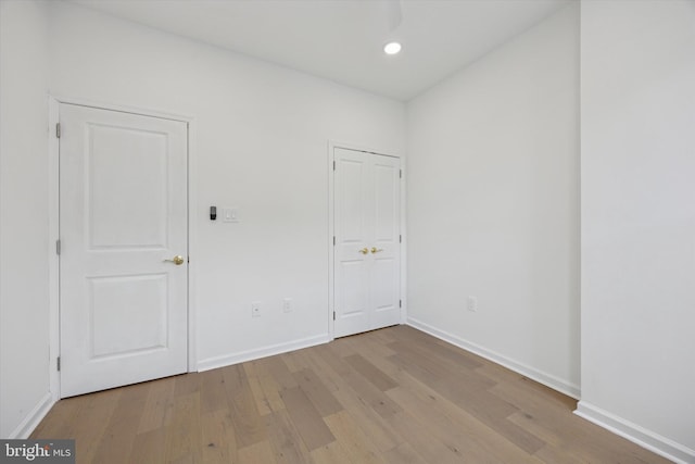 unfurnished room with recessed lighting, baseboards, and wood finished floors