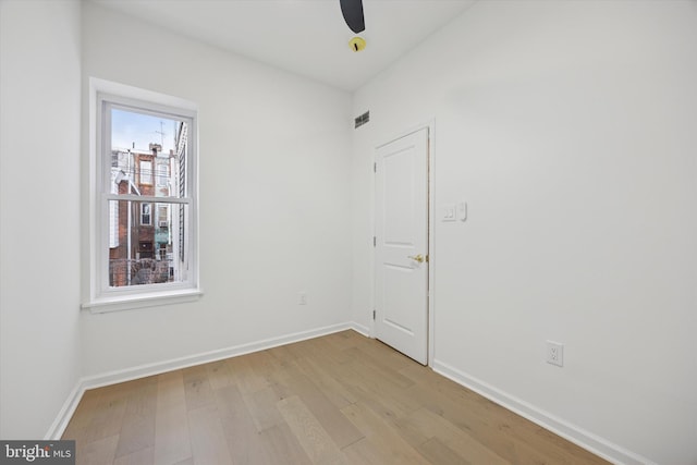 spare room with light wood-style flooring, visible vents, baseboards, and ceiling fan