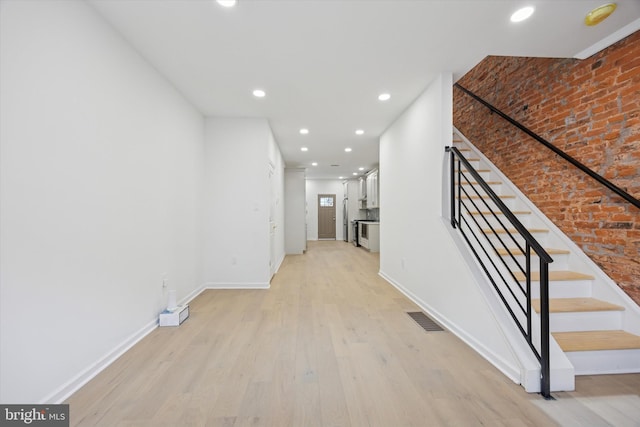 hallway featuring stairway, recessed lighting, light wood-style floors, and visible vents