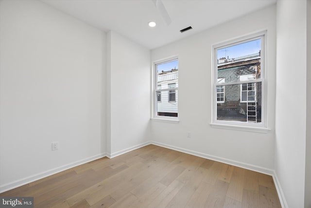 empty room with visible vents, recessed lighting, baseboards, and wood finished floors