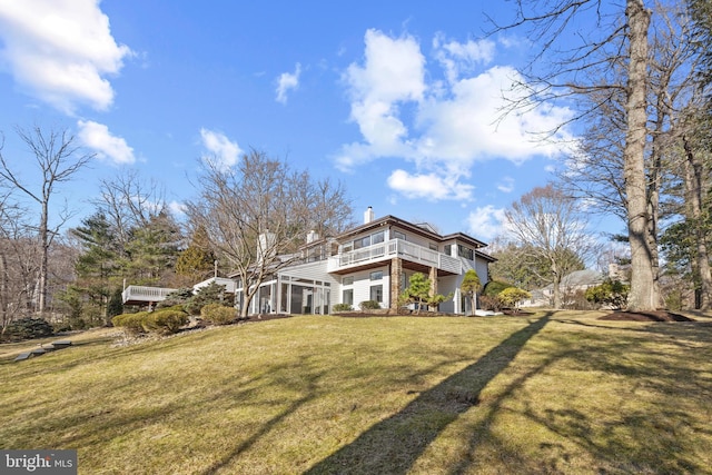 back of house featuring a lawn and a chimney