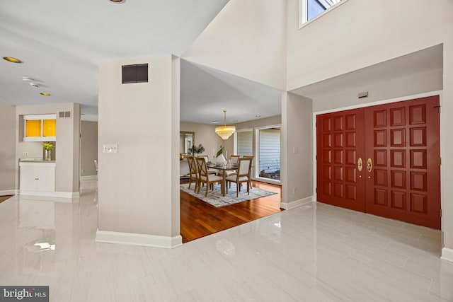 foyer entrance featuring visible vents and baseboards