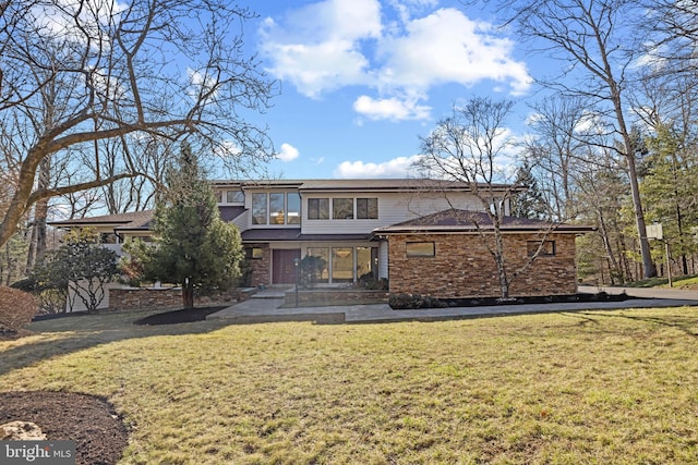 view of front facade with a front lawn and stone siding