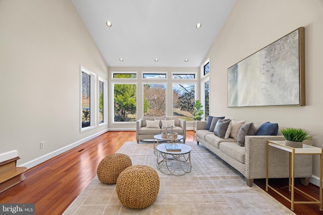 living room featuring visible vents, baseboards, recessed lighting, wood finished floors, and high vaulted ceiling