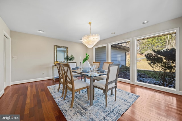 dining space featuring visible vents, a notable chandelier, hardwood / wood-style flooring, recessed lighting, and baseboards